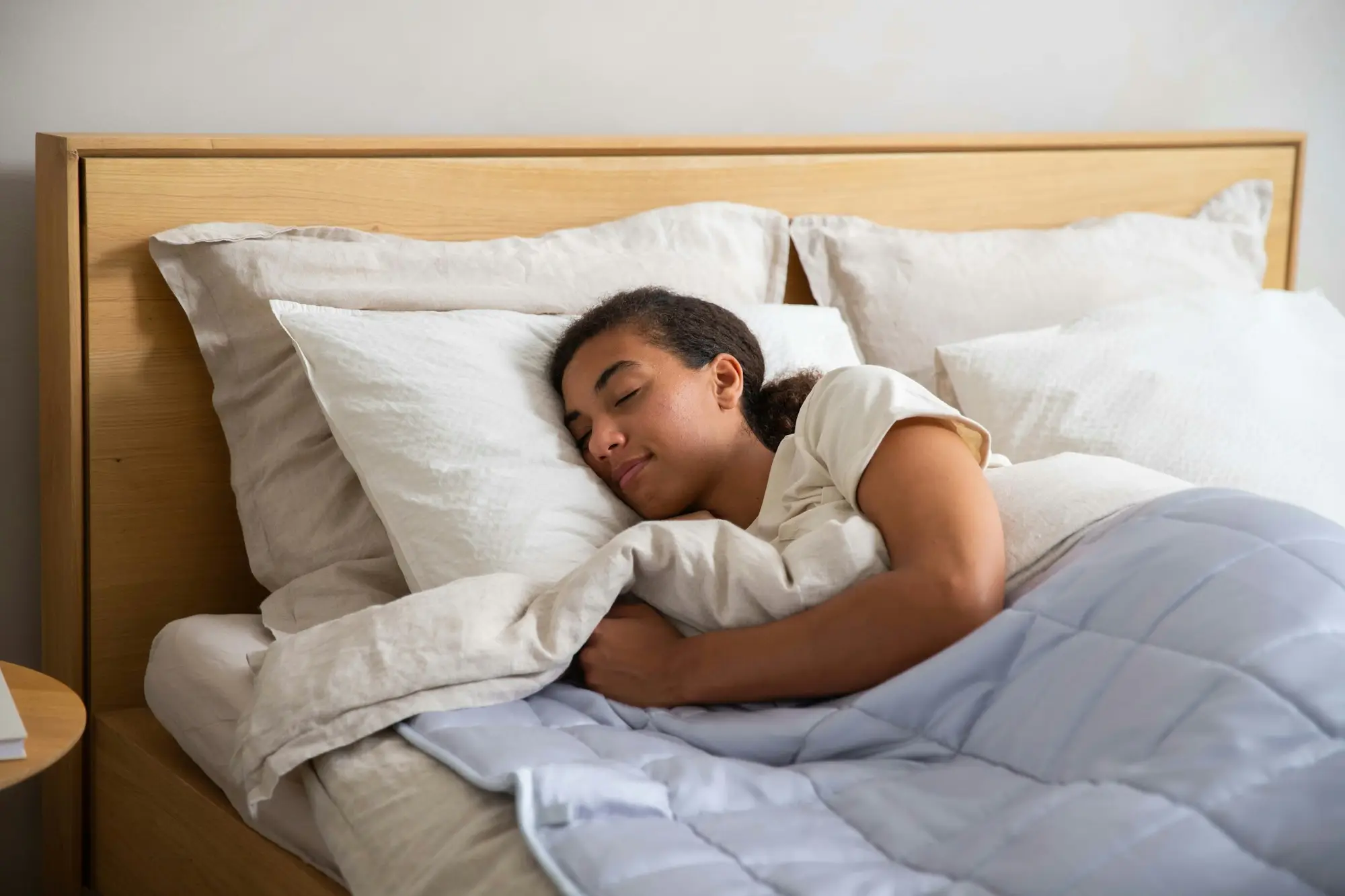 A woman asleep in a bed with white linen